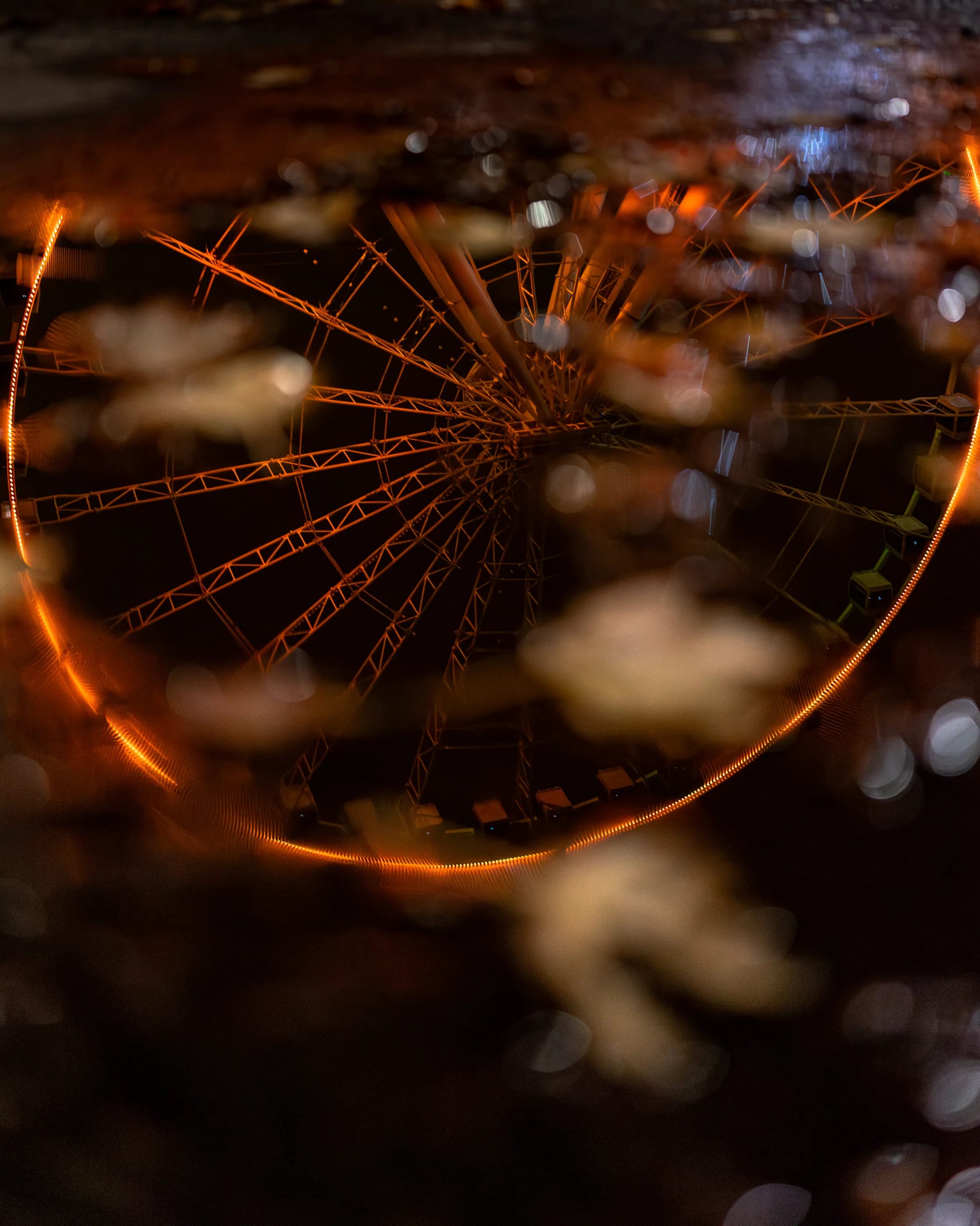 The orange Grande Roue glowing through rain